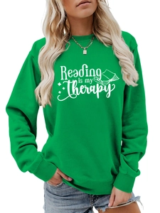 Detail of green crewneck sweatshirt featuring Reading is my Therapy white slogan print