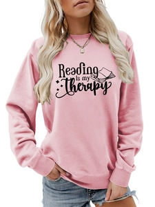 Detailed view of Reading is my Therapy text and book illustration on pink sweatshirt