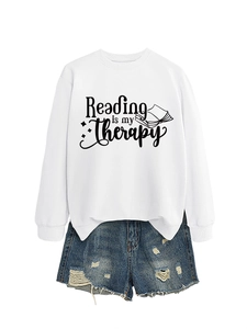 Close-up of Reading is my Therapy print on white long sleeve sweatshirt with denim shorts