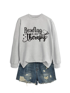 Detail of grey Reading is my Therapy sweatshirt paired with distressed denim shorts