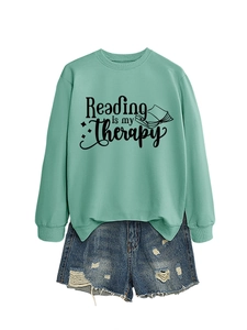 Detail of mint green Reading is my Therapy sweatshirt with ribbed cuffs and book print