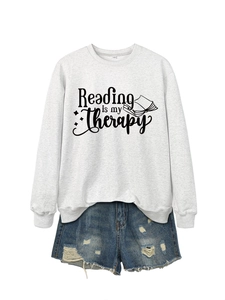 Detail of gray sweatshirt fabric with Reading is my Therapy print and size tag