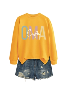 Détail du sweat-shirt col rond jaune gingembre avec imprimé OMA life et short en jean vieilli