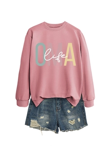 Détail du sweat rose OMA life avec imprimé lettres, poignets côtelés et short en denim bleu