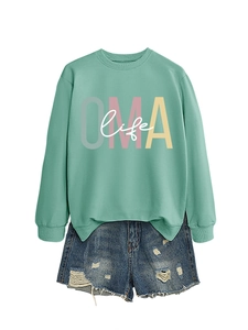 Détail à plat du sweat-shirt vert menthe OMA life et du short en jean vieilli