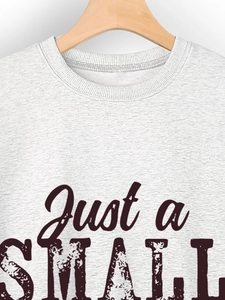 Detail of grey sweatshirt neckline and vintage Just a Small Town Girl printed text