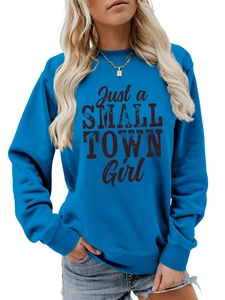 Close-up of Just a Small Town Girl black text print on a royal blue crewneck sweatshirt