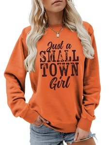 Detail of bright orange crewneck sweatshirt with Just a SMALL TOWN Girl black print