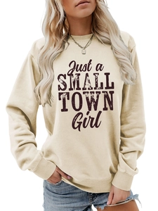 Detail of vintage 'Just a SMALL TOWN Girl' typography on a cream crewneck sweatshirt
