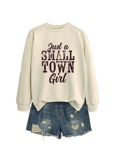 Flat lay of cream crewneck sweatshirt with Just a Small Town Girl text and ripped denim shorts