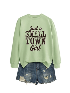 Detail of sage green sweatshirt with Just a Small Town Girl print and ripped denim shorts