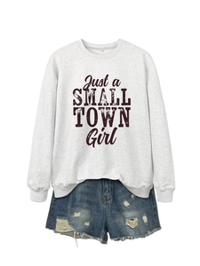 Flat lay of a grey sweatshirt featuring Just a Small Town Girl text with denim shorts