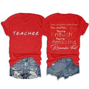 Detail view of red cotton tee with white Teacher print and distressed denim shorts