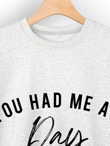 Detail of white cotton sweatshirt featuring a ribbed neckline and stylish slogan print