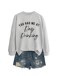 Close-up of gray crewneck sweatshirt with 'YOU HAD ME AT Day Drinking' slogan print