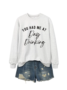 Flat lay of gray long-sleeve sweatshirt with black text and distressed denim shorts