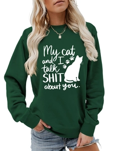 Detail of dark green crewneck sweatshirt featuring white cat print and humorous slogan