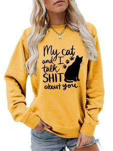 Detail of 'My cat and I talk shit' slogan and cat silhouette print on yellow sweatshirt