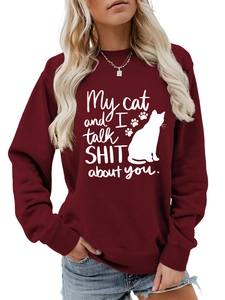 Detail of burgundy sweatshirt featuring a white cat print and humorous text on the front