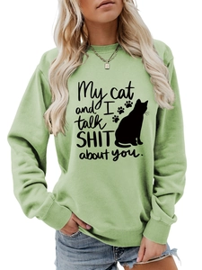 Detail of mint green sweatshirt featuring a black cat and funny slogan print