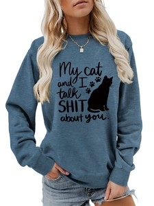 Detail of blue crewneck sweatshirt featuring a funny cat slogan and ribbed cuffs