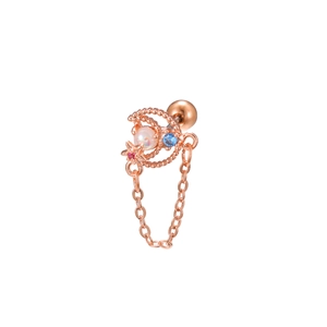 Macro detail of rose gold moon ear stud with pearl, blue zircon, and star chain