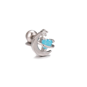 Macro shot of silver crescent moon cartilage stud with blue heart stone and star charms