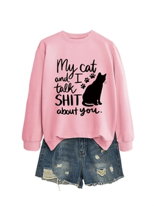 Detail of pink crewneck sweatshirt featuring cat silhouette and funny text with denim shorts