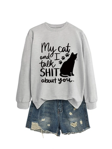 Close-up of light grey sweatshirt with funny cat text print and distressed denim shorts