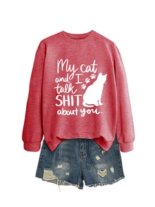 Detail of red sweatshirt with My cat and I talk SHIT about you print and denim shorts