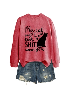 Detail of red sweatshirt with cat silhouette and funny slogan paired with denim shorts