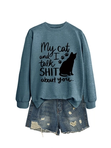Close-up of crewneck sweatshirt with 'My cat and I talk SHIT about you' text and denim shorts