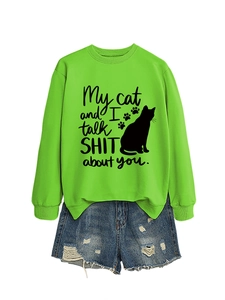 Detail of neon green sweatshirt featuring black cat silhouette and humorous text print