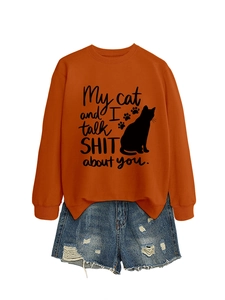 Detail of the orange sweatshirt showing the cat print and humorous quote on fabric
