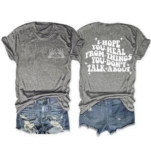 Détail d'un t-shirt gris chiné avec motif main-cœur et texte I Hope You Heal au dos