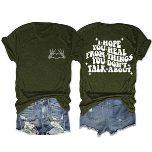 Détail du t-shirt vert armée avec slogan I Hope You Heal et imprimé main en cœur