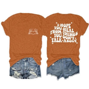 Détail d'un t-shirt orange en coton avec slogan blanc et imprimé cœur d'os