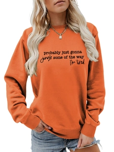 Detail of orange crewneck sweatshirt featuring black letter print and casual cotton texture