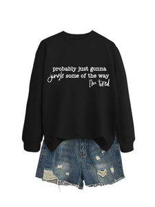 Detail of black crewneck sweatshirt with slogan and distressed denim shorts set