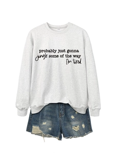 Close-up of gray 'Probably Just Gonna Jingle' sweatshirt with distressed denim shorts