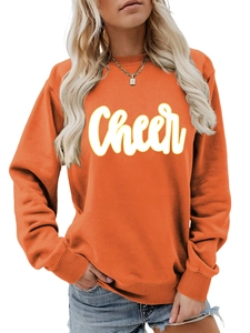 Detail eines orangen Sweatshirts mit weißem Cheer-Schriftzug und gerippten Ärmelbündchen