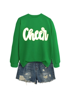 Flachbild eines grünen Cheer-Sweatshirts mit zerrissenen Denim-Shorts für Damen