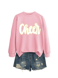 Detail eines rosa Langarm-Sweatshirts mit Cheer-Print und Distressed-Denim-Shorts