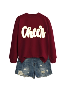 Detail von burgunderrotem Langarm-Sweatshirt mit weißem Cheer-Text und Distressed-Denim-Shorts