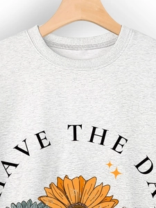 Detail of sunflower print and Save The Day text on light grey crewneck sweatshirt
