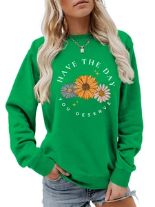 Detailed view of floral print and Have The Day You Deserve slogan on green sweatshirt