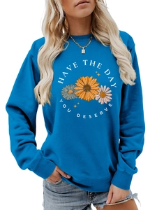 Close-up of blue crewneck sweatshirt with colorful daisy flowers and printed text