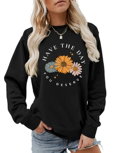 Detailed view of daisy floral print and 'Have the day you deserve' slogan on black sweatshirt