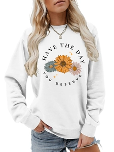 Detail of sunflower print and Have The Day You Deserve text on white sweatshirt