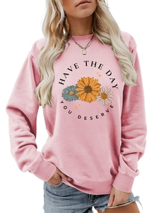 Detail of the pink daisy flower print and Have The Day You Deserve text on the sweatshirt